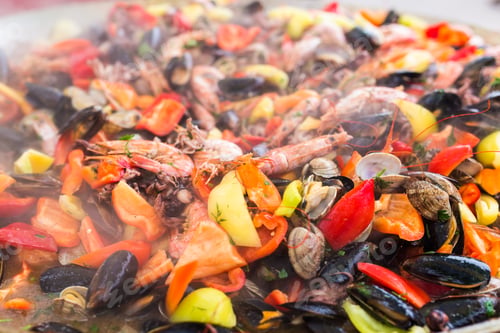 Preview: Street food concept - Gourmet seafood paella with pink marine prawns and mussels on yellow saffron