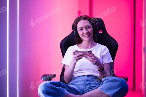 Smiling Woman Playing Mobile Game at Home