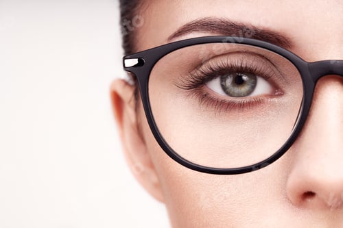 Preview: Female eye with long eyelashes in eyeglasses