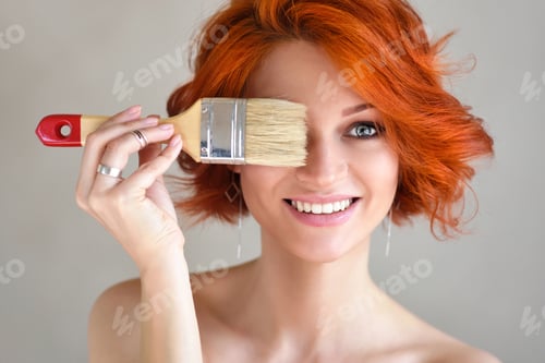 Preview: Smiling Woman Holding Paintbrush Up to Her Eye