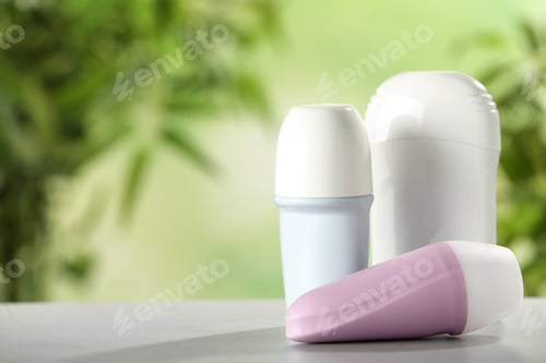 Preview: Different deodorants on white wooden table against blurred background. Space for text