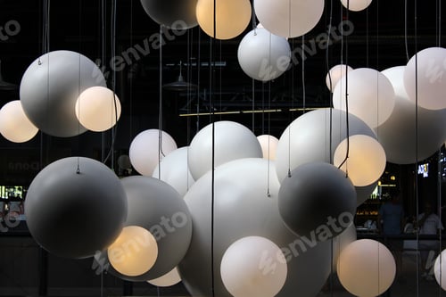 Preview: Spheres of light in various shades of gray hanging from the ceiling