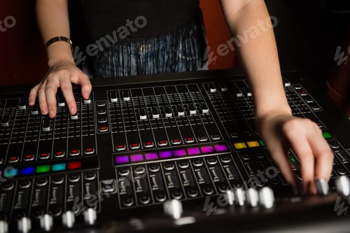 Preview: Mid-section of female audio engineer using sound mixer