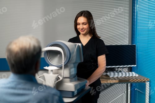Preview: ophthalmology clinic a female doctor in a black uniform performs a diagnosis on an elderly patient