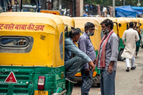 Preview: Auto rickshaw drivers chatting next to their vehicles in Delhi, India