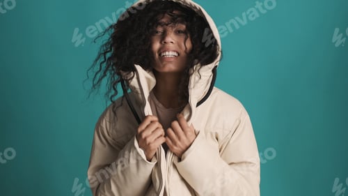 Preview: Young African American woman dressed in down jacket with hood lo