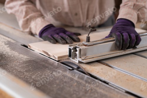 Preview: Close up image of carpenter hand using circular saw machine in carpentry workshop