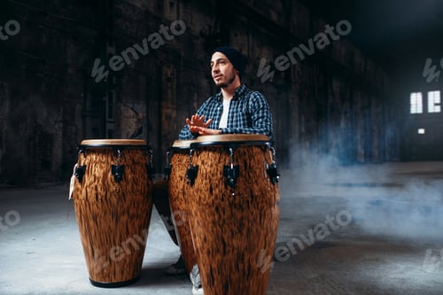 Vista previa: El baterista masculino toca tambores de madera en la tienda de la fábrica