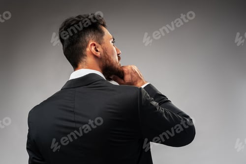 Preview: Studuo shot of thinking businessman standing over gray background