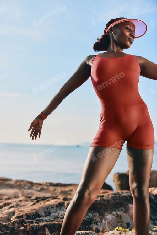 Preview: Woman in a red swimsuit posing cheerfully on a sunny beach during the day