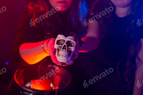 Preview: Two halloween witches making magic in halloween night. Magic, holidays and mystic concept.