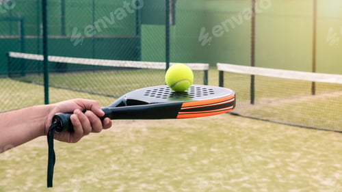 Preview: Professional monitor of padel holding a black racket with a yellow ball on top