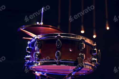 Preview: Snare drum and drumsticks close up in dark.