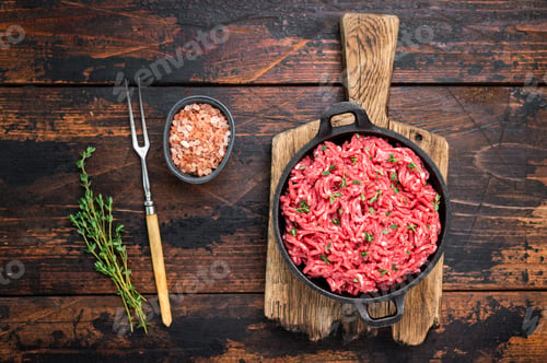 Preview: Veal beef raw mince meat, forcemeat in a skillet, on wooden background.