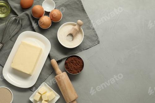 Preview: Flat lay composition with fresh butter and other products on grey table. Space for text