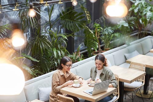 Preview: Contemporary Women Enjoying Coffee in Outdoor Cafe