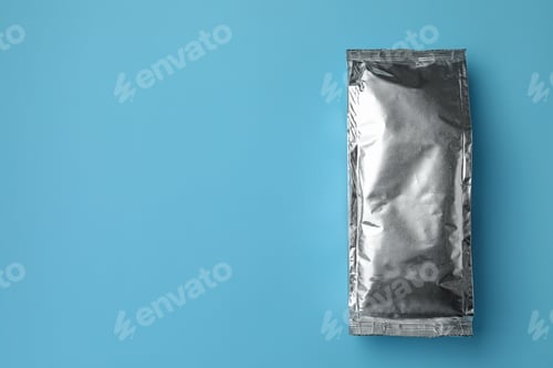 Preview: Blank foil package on light blue background, top view. Space for text