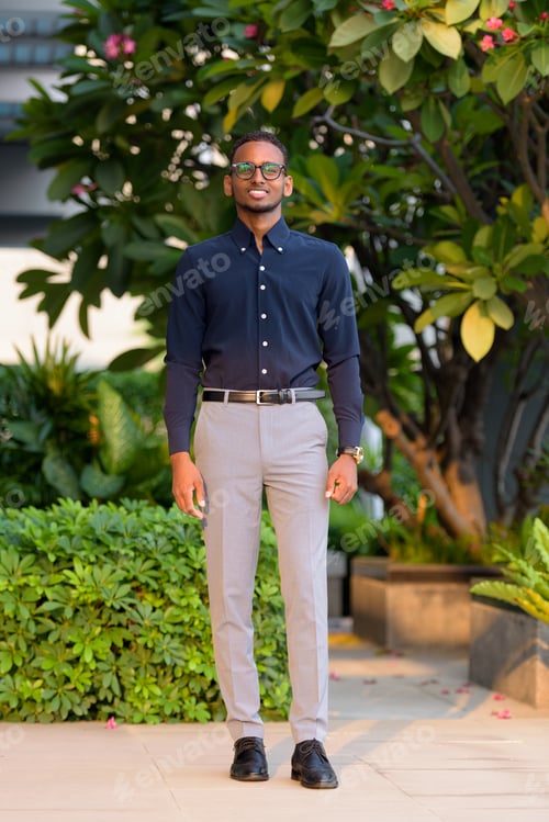 Preview: Full length shot of handsome African businessman outdoors at rooftop garden smiling