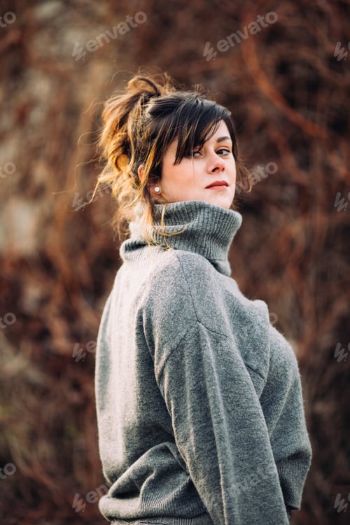 Preview: Woman Wearing a Grey Sweater Looks Over Shoulder