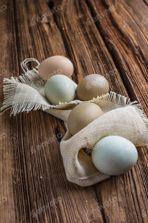 Preview: Brown, green eggs on wooden table. Chicken, Hen eggs