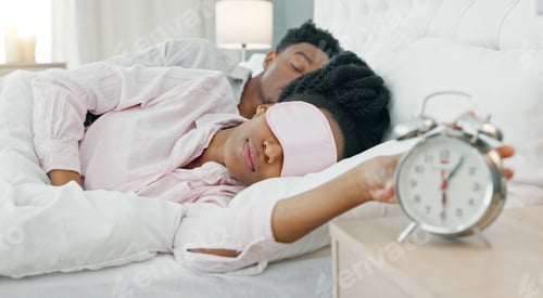 Preview: Black woman waking up in bed to switch off her alarm clock with a sleep mask in her house. Lazy, sl