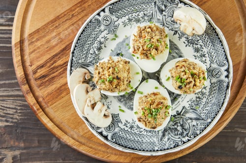 Preview: Stuffed Mimosa eggs with mushrooms in vintage plate. French gourmet cuisine