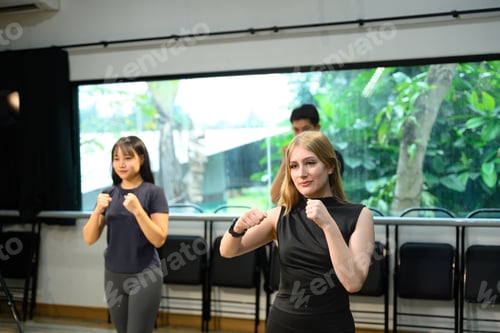 Preview: Fitness instructor leading boxing workout with students following punching exercises