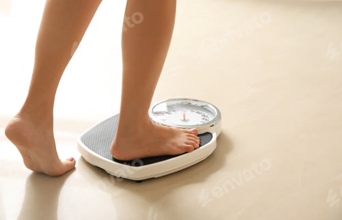 Preview: Woman stepping on floor scales indoors, space for text. Overweight problem