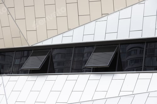 Preview: Outside view on white tiled wall of building with few black tinted windows opened