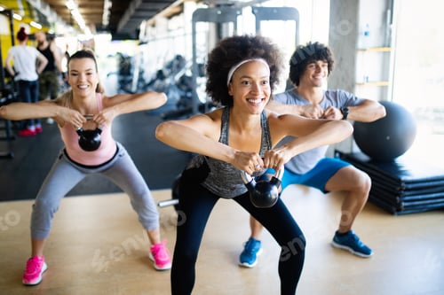 Preview: Healthy young athletes doing exercises at fitness studio