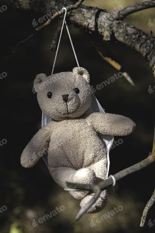 Preview: Closeup shot of a toy bear hanging on a tree branch