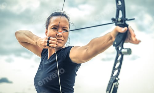 Preview: attractive woman on archery, focuses eye target for arrow from bow. cinema form