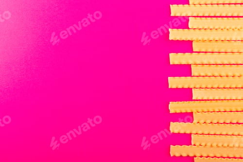 Preview: a top view dry italian pasta long raw lined on the pink background food meal italian spaghetti