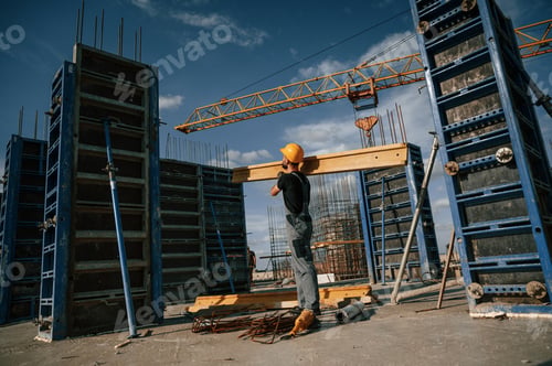 Preview: Yellow colored wooden plank. Man in uniform is working on the construction site