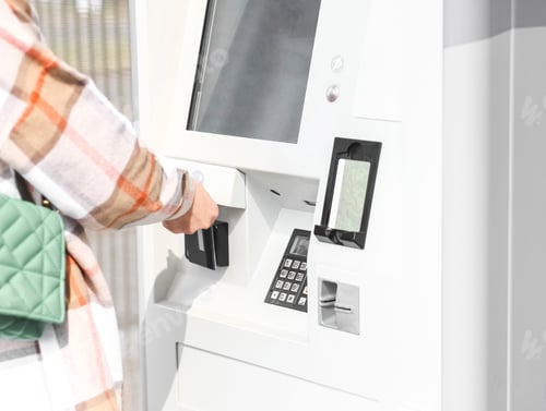 Preview: Young caucasian woman makes a payment with a bank card via wi-fi, topping up her travel ticket