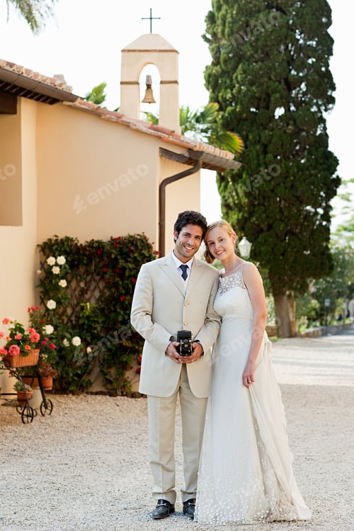 Preview: Portrait of newlyweds, groom holding vintage camera