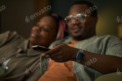 Preview: Black Man Relaxing with Remote Control Beside Black Woman