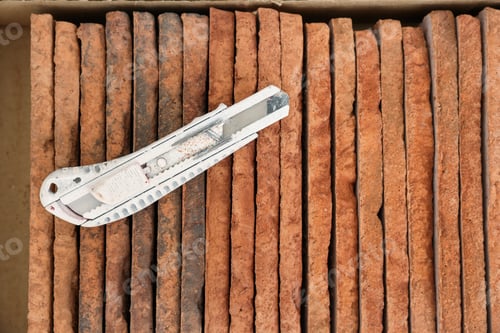 Preview: Box with many decorative bricks and utility knife, top view
