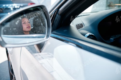 Preview: young latin woman driving a luxury car