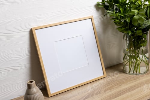 Preview: Wood empty frame with copy space and plants in pots on table against white wall
