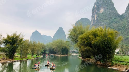 Preview: Some tourists are drifting in the river of Guilin, where is famous with it’s beautiful mountains.