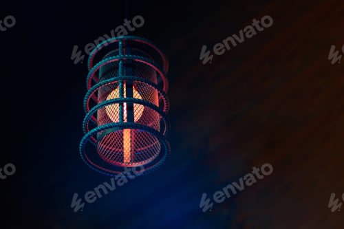 Preview: Loft pendant lamp with red blue glow in steel rebar shade, wooden interior background, copy space