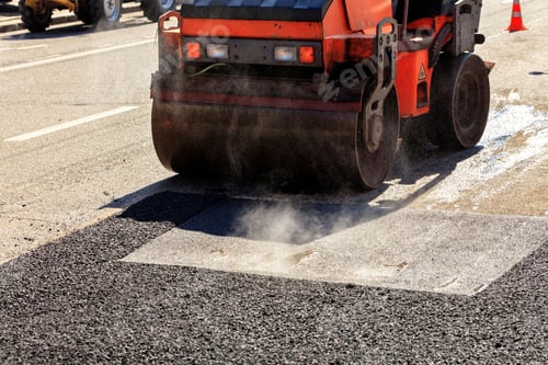 Preview: Heavy vibrating roller compacting hot asphalt on a repaired asphalt surface