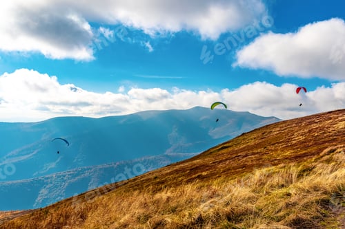 Preview: Paragliding active sport against giant mountains in highland