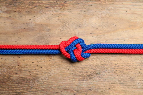 Preview: Colorful ropes tied together on wooden background, top view. Unity concept