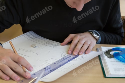 Preview: A student performs a task on engineering graphics - draws a drawing with a pencil