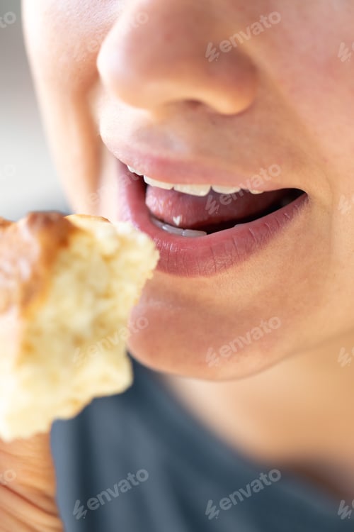 Preview: Detailed shot of a woman eating fresh bun.