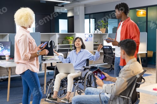 Preview: Diverse colleagues use smartphones and laptops in a modern office for business