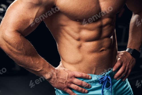 Preview: Muscled sportsman posing with his arms on his hips