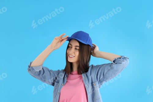 Preview: Attractive girl in cap on blue background